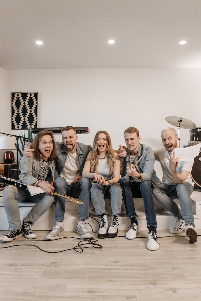 Lively band posing indoors with instruments, showcasing unity and enthusiasm.